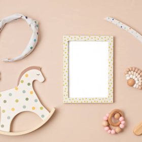 Mockup of empty frame with eco friendly baby accessories. Baby shower invitation, greeting card. Template for brand, logo, advertising. Flat lay, top view